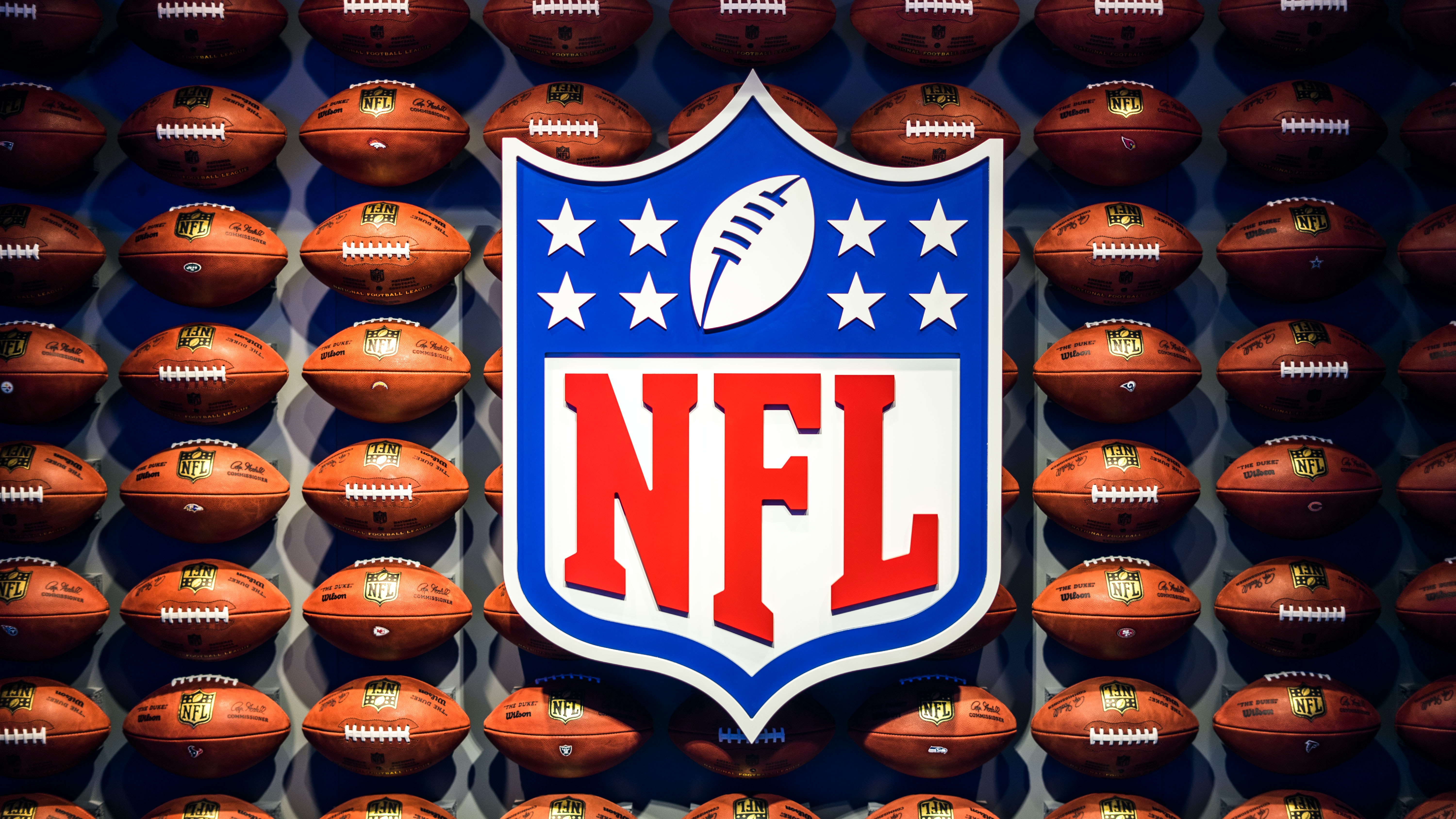 NFL logo with footballs in the background